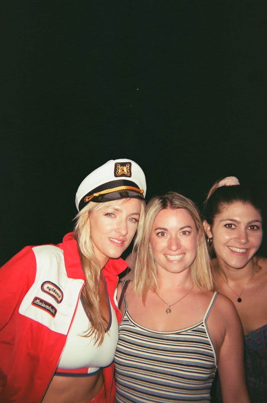 Three friends in captain hats at a boat party