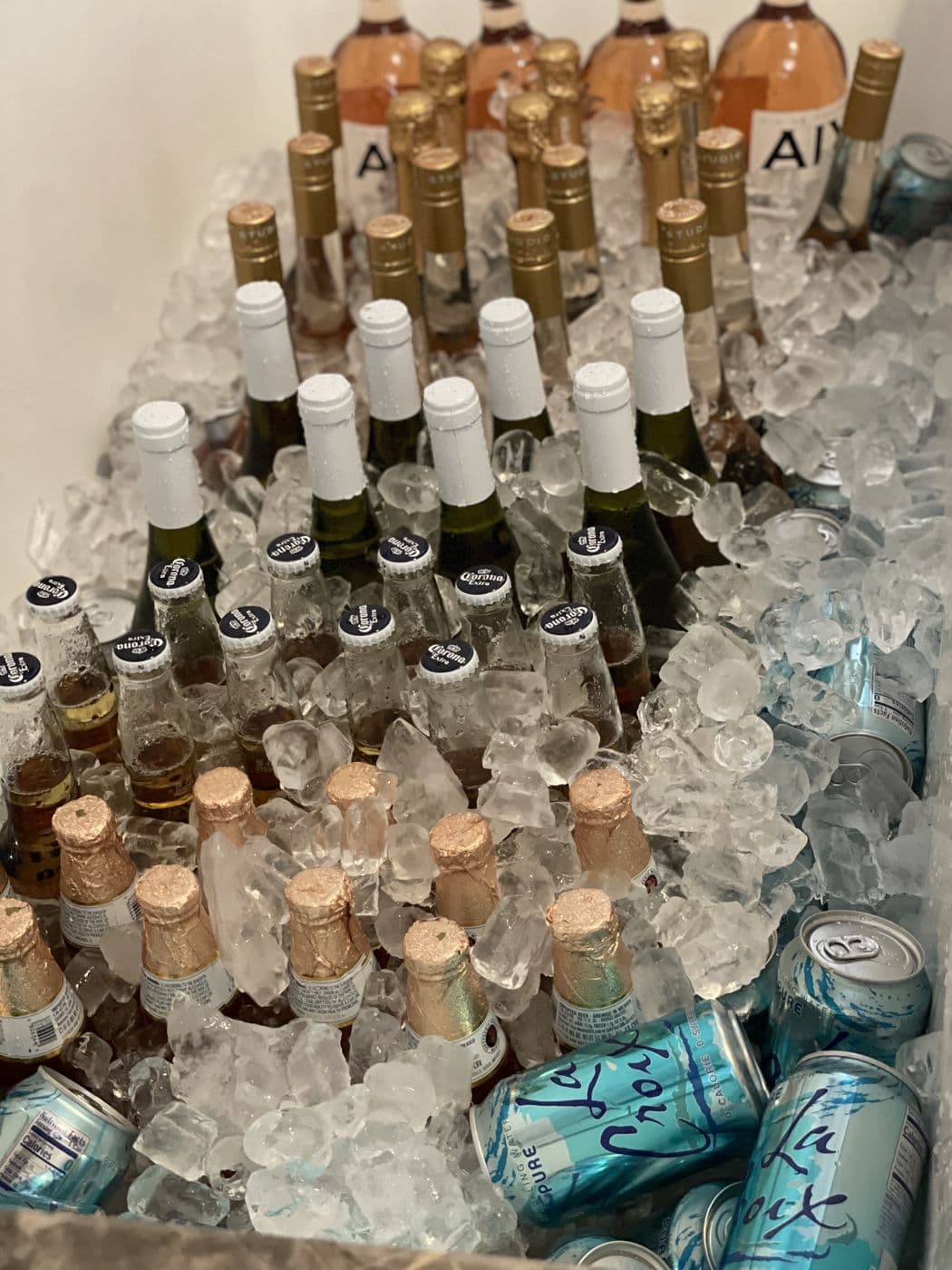 Champagne bottles and cans stacked on ice