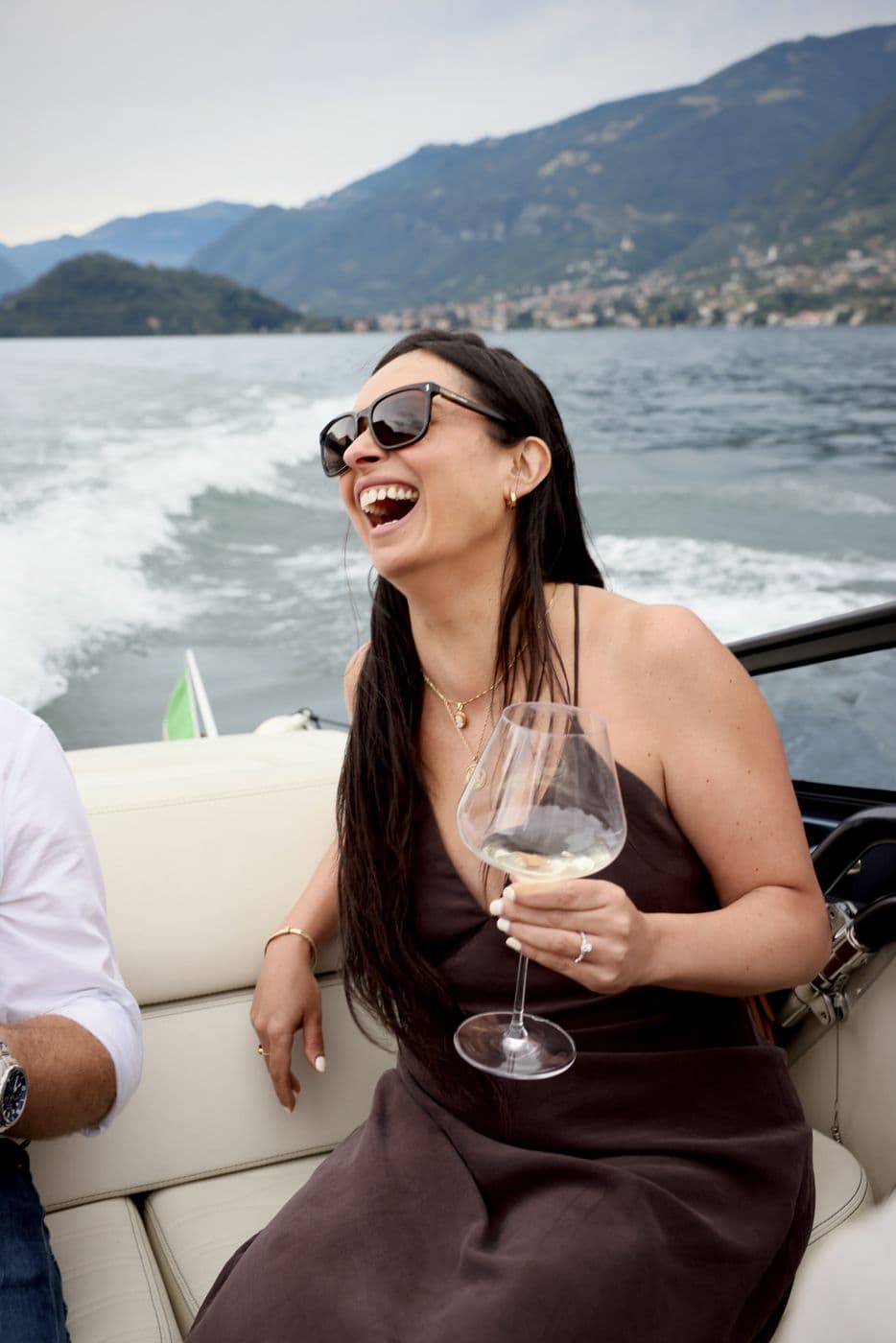 Guest laughing on a speedboat on an alpine lake