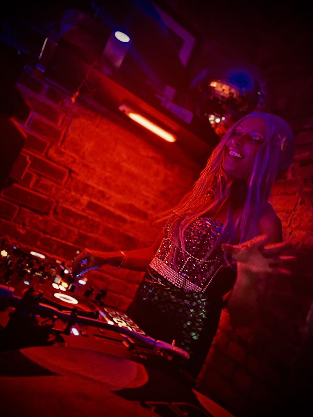 DJ performing under red light