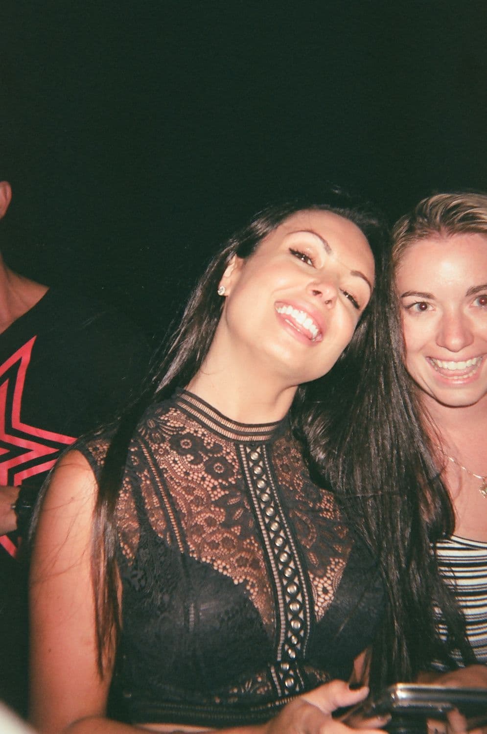 Flash-lit portrait of two friends mid-laugh