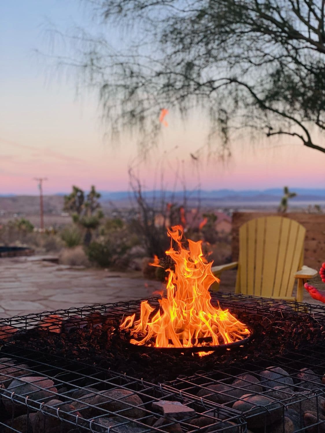 A desert fire pit blazing at dusk in Joshua Tree