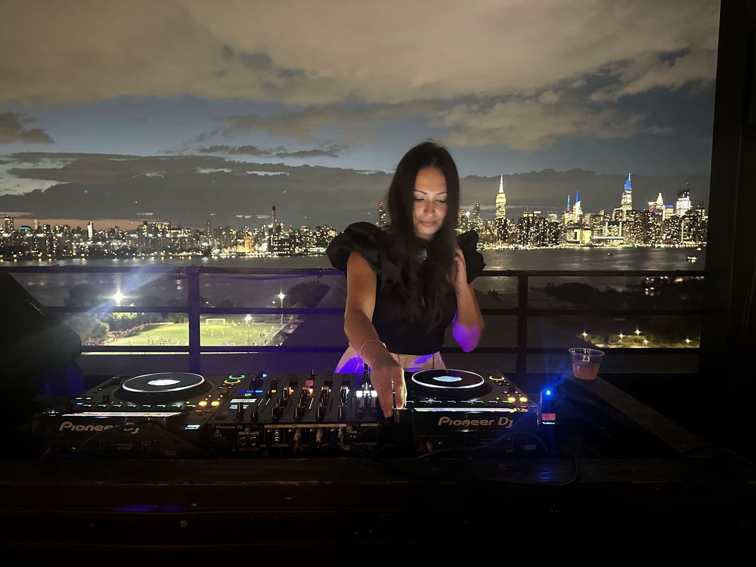 Lina Grace on the decks, Manhattan skyline behind