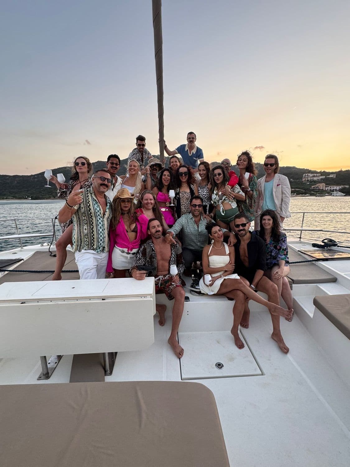 The whole charter gathered on the stern at dusk in the Med