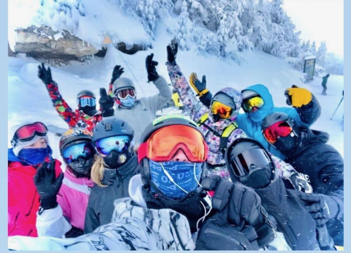 Crew in ski gear celebrating in deep snow