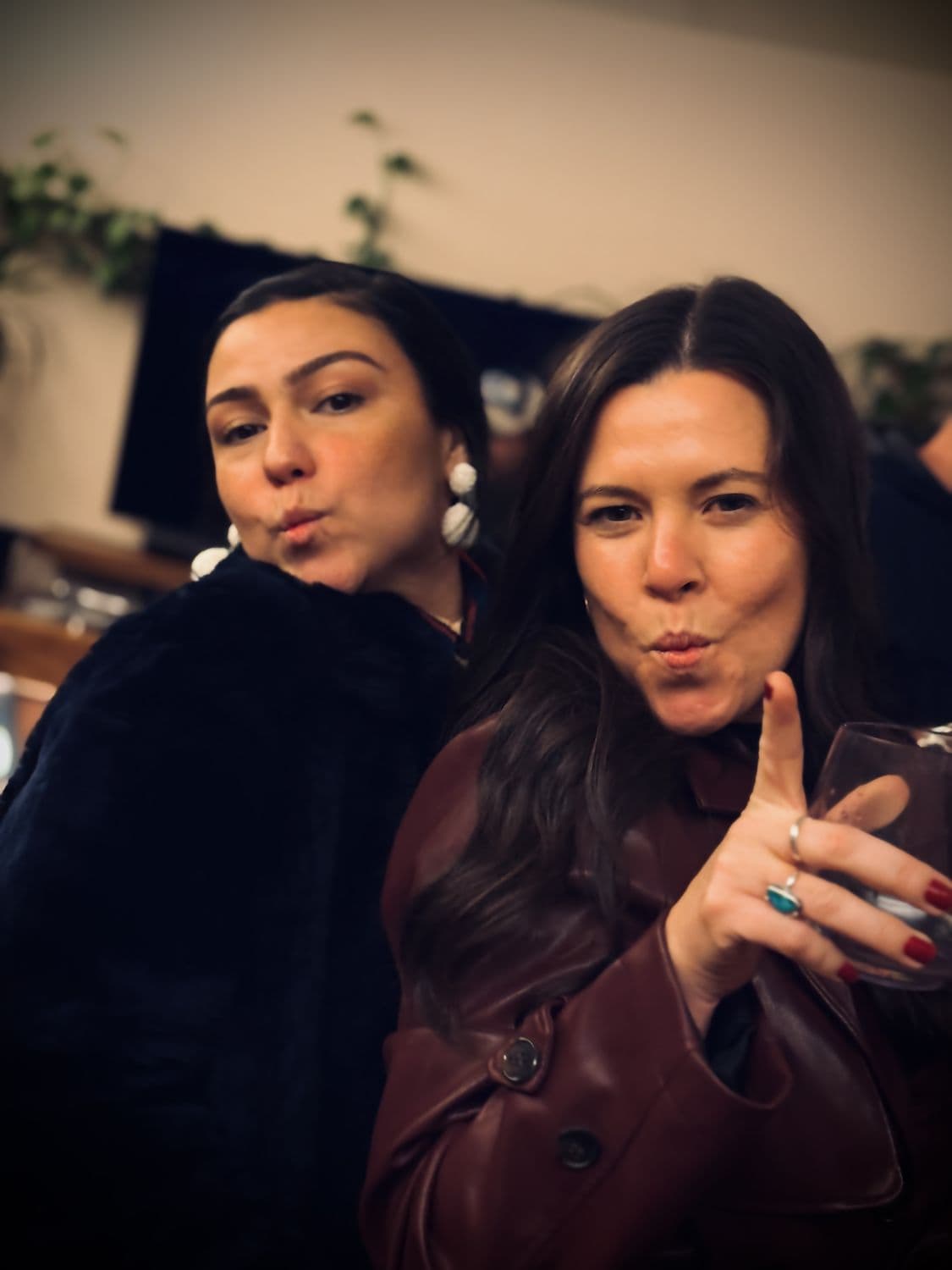 Two friends posing at a wine bar