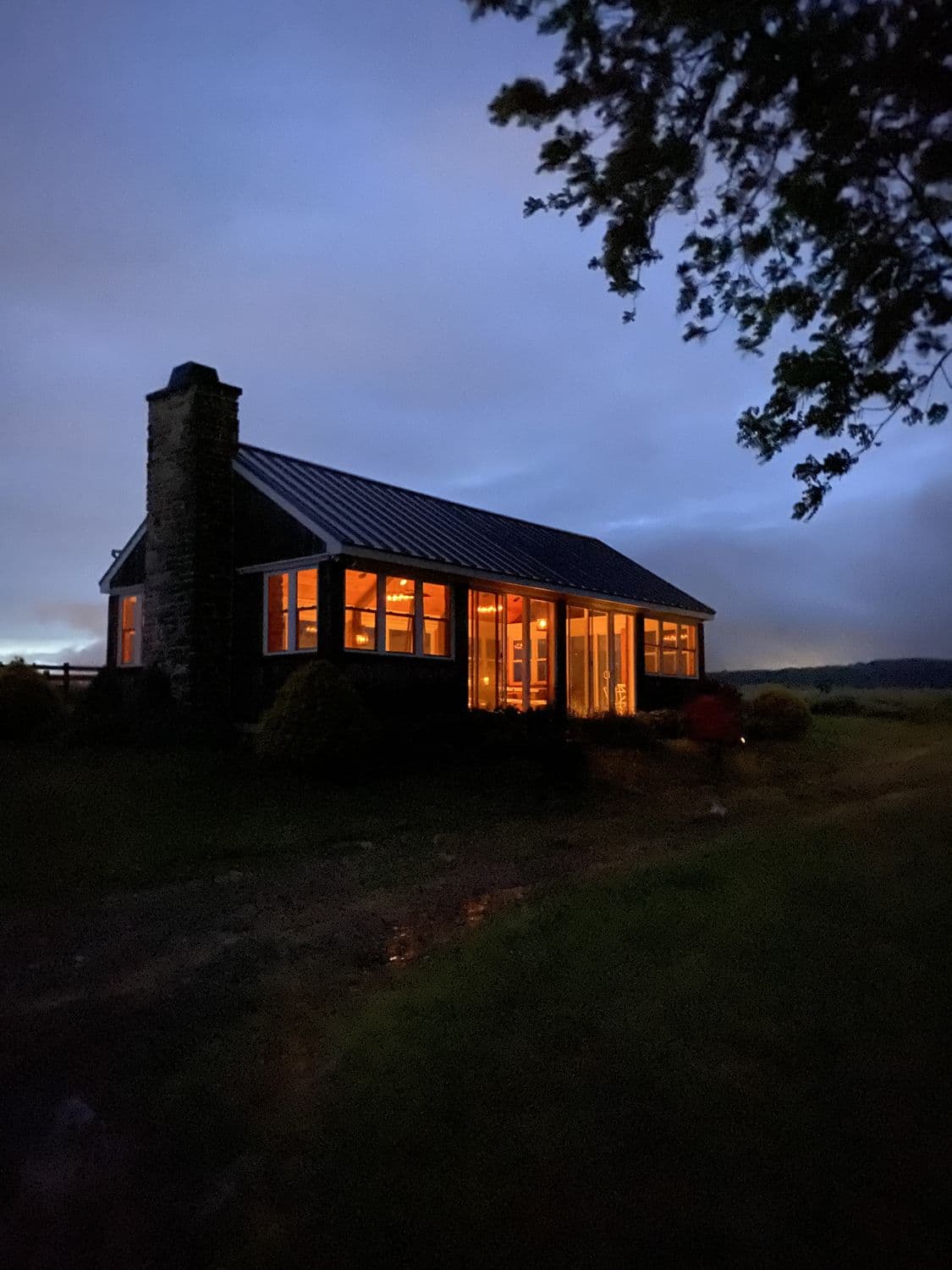 Lake house glowing at dusk in the woods