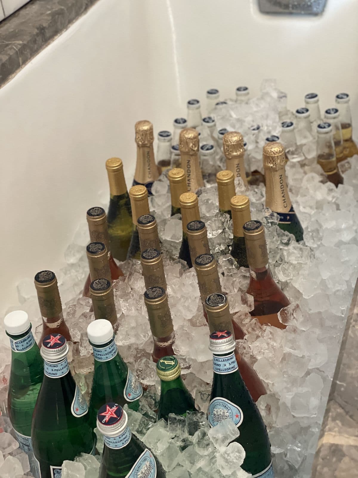 A bathtub stocked with champagne and sparkling water on ice