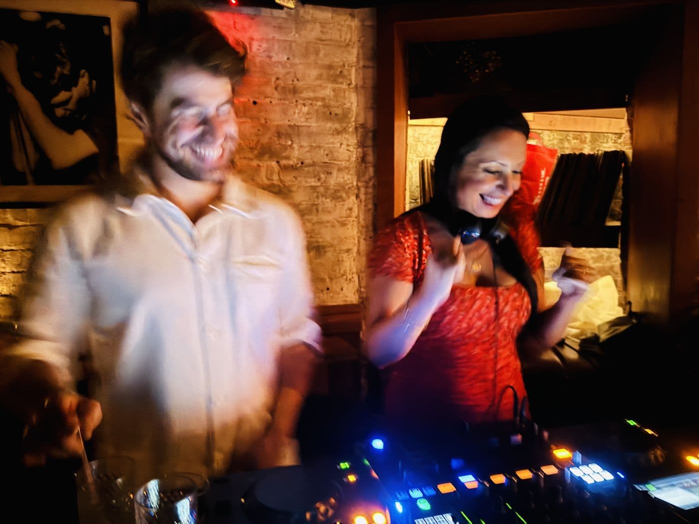 Two DJs playing back to back under red light