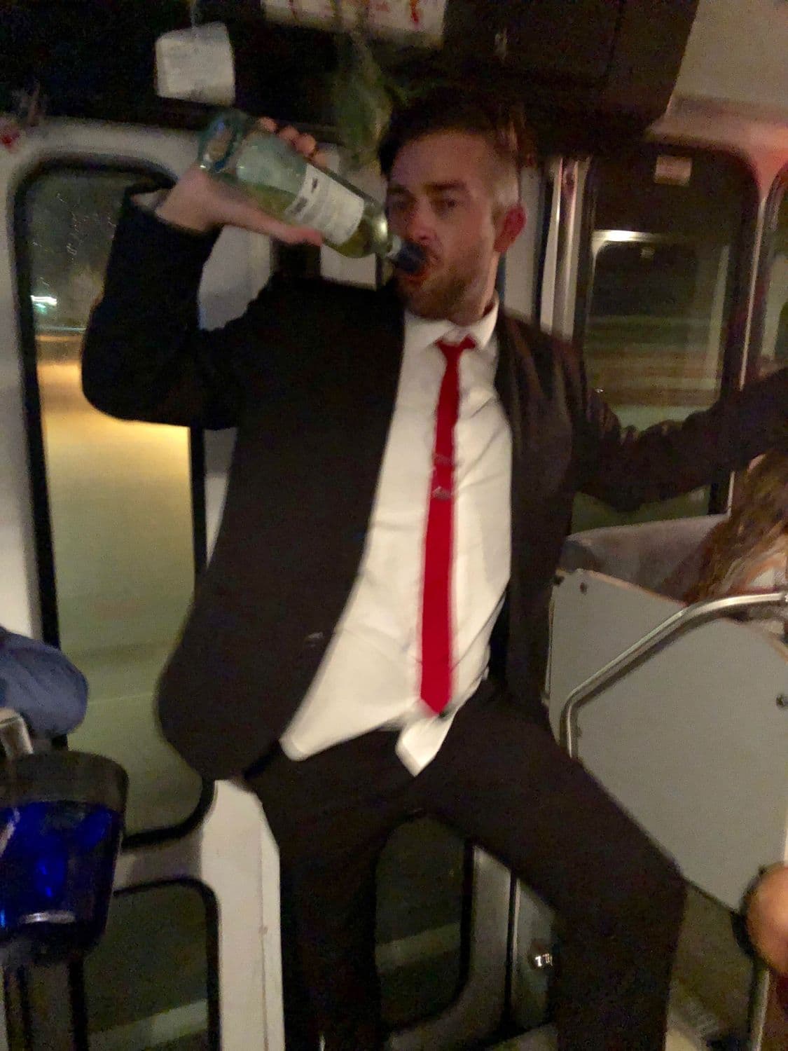 Guest in a suit celebrating chaotically on a party bus